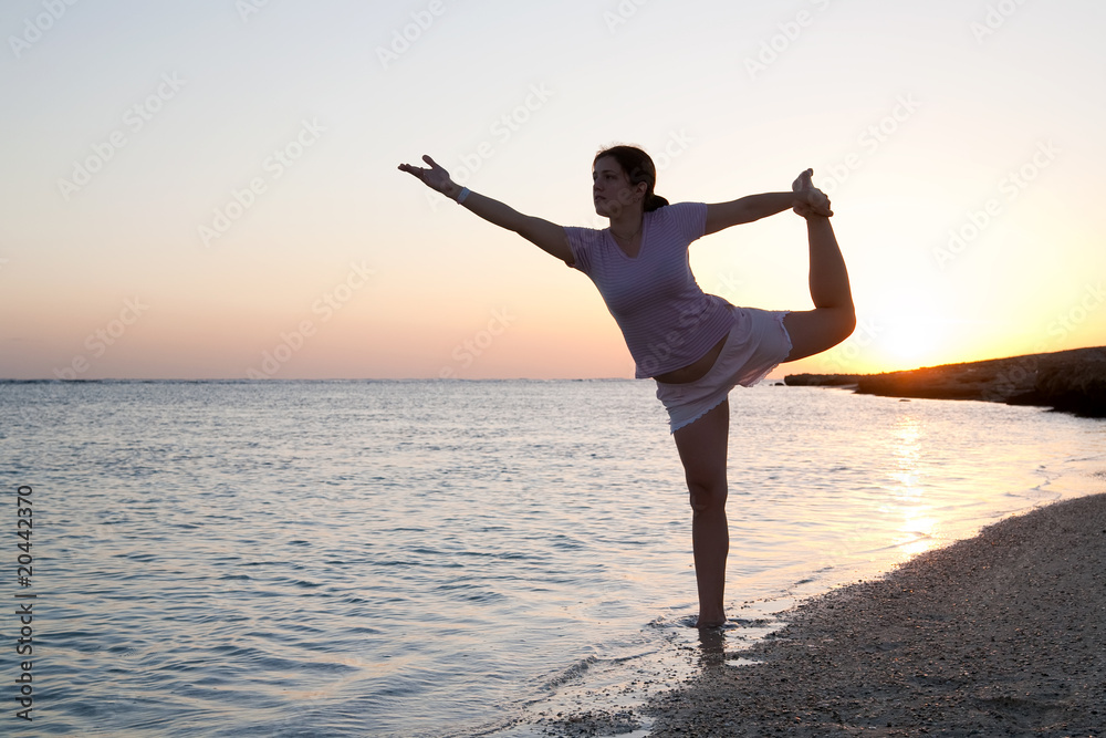girl doing yoga against sunset