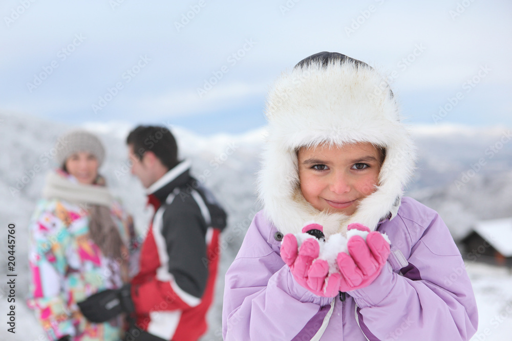 Fillette portant de la neige dans ses mains