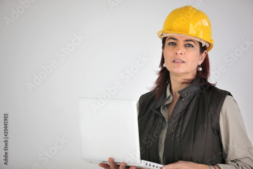 Femme chef de chantier avec casque de sécurité et ordinateur