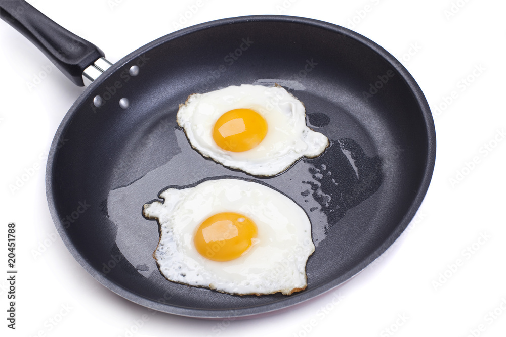 fried eggs in a frying pan on white background fried eggs in a frying pan on white background