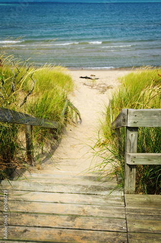 Fototapeta Wooden stairs over dunes at beach