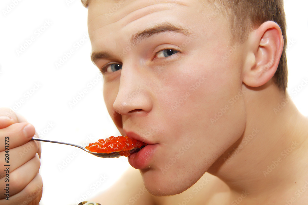 young man eating red caviar young man eating red caviar