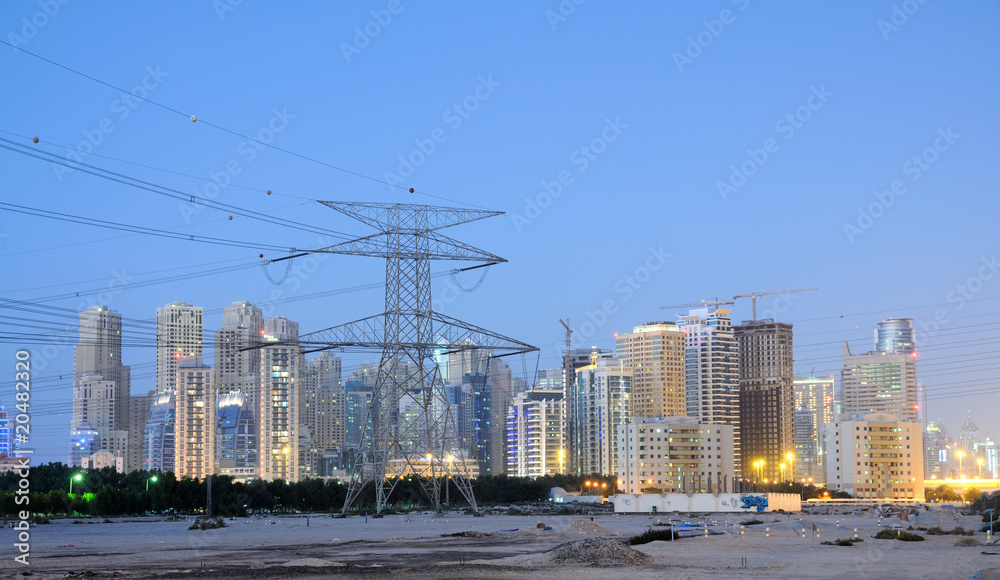 Fototapeta premium Electrical Tower and Dubai City, United Arab Emirates