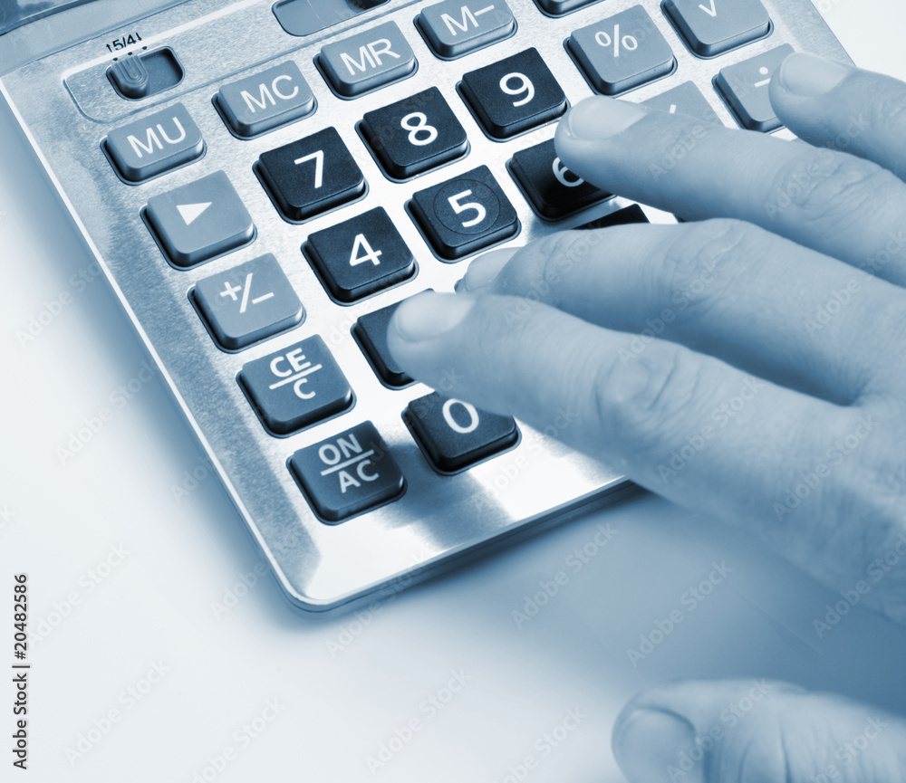 The calculator and a hand of the man The calculator and a hand of the man