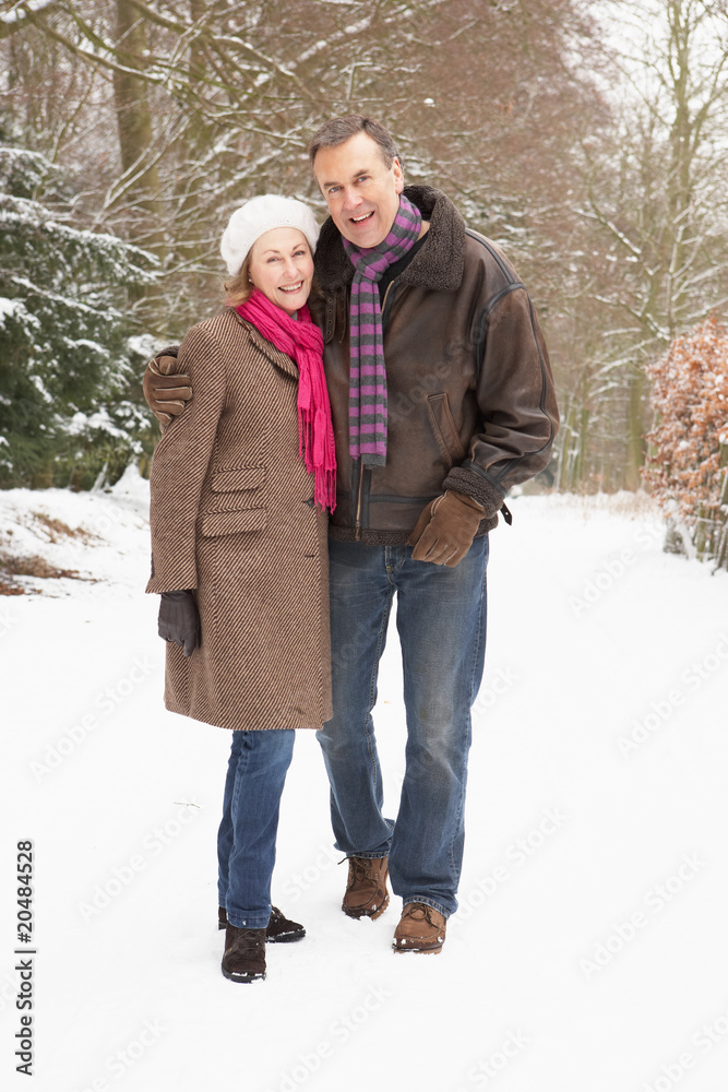 Senior Couple Walking Through Snowy Woodland Senior Couple Walking Through Snowy Woodland