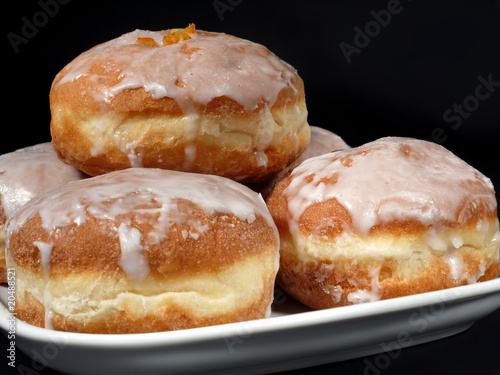 Polish donuts with icing over black background