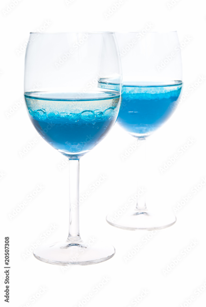 two glass with colored blue liquid on a white background two glass with colored blue liquid on a white background
