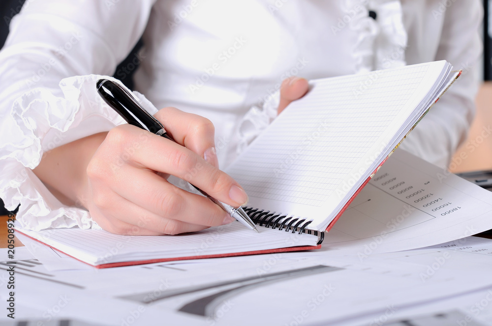 Fototapeta premium hand of a young business woman working with documents
