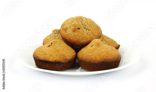 Freshly baked bran muffins on white plate