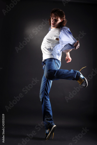 young man modern dancer in action against black © konstantant