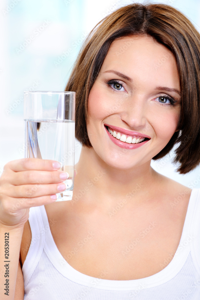 smiling woman holds a glass of clean water smiling woman holds a glass of clean water