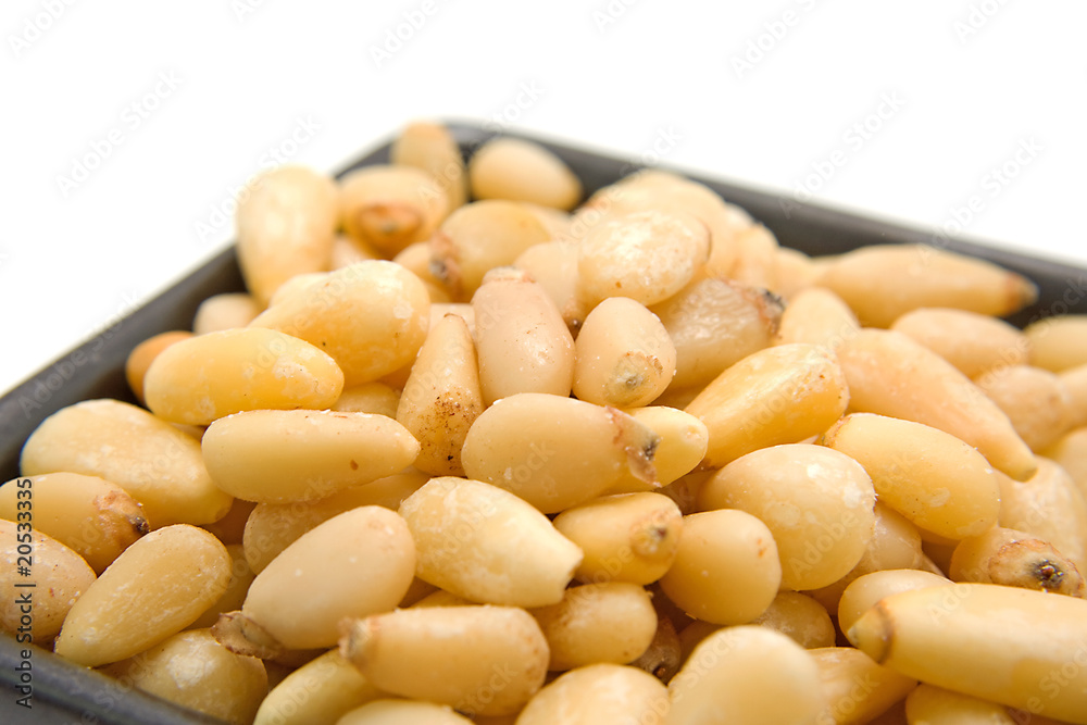little bowl with pine nuts over white background little bowl with pine nuts over white background