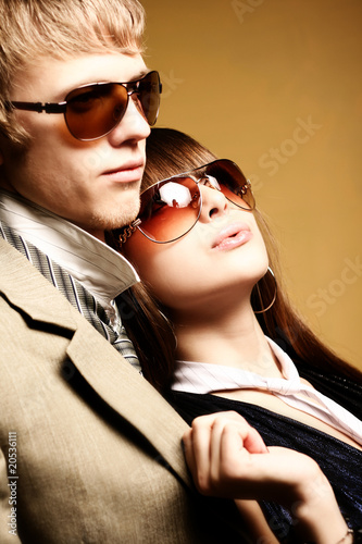 Fashionable young couple wearing sunglasses