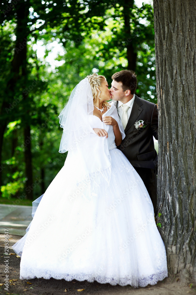 Happy bride and groom in wedding walk in park