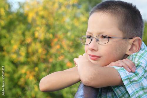 boy is lean elbow on bridge fence and looking forward