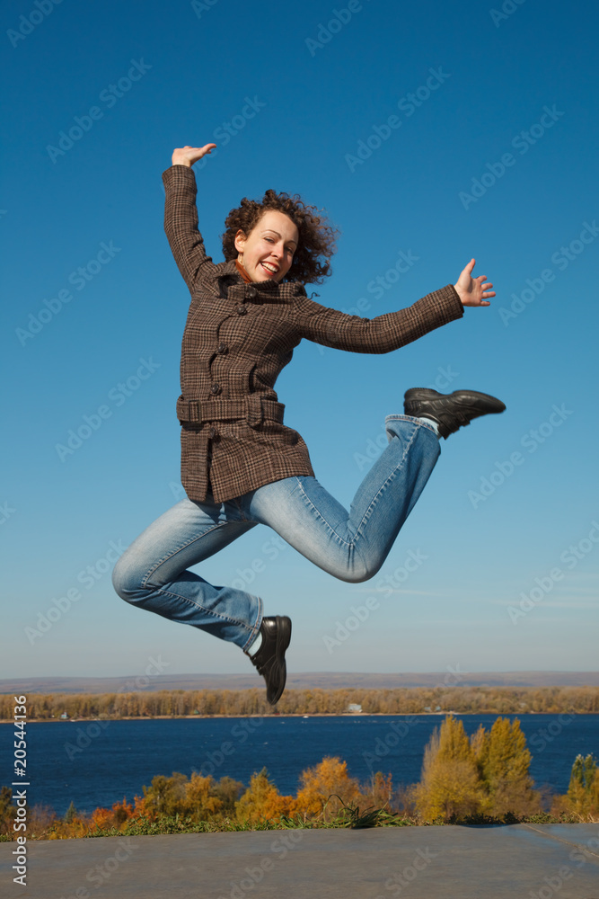Cheerful girl in jump against dark blue sky Cheerful girl in jump against dark blue sky