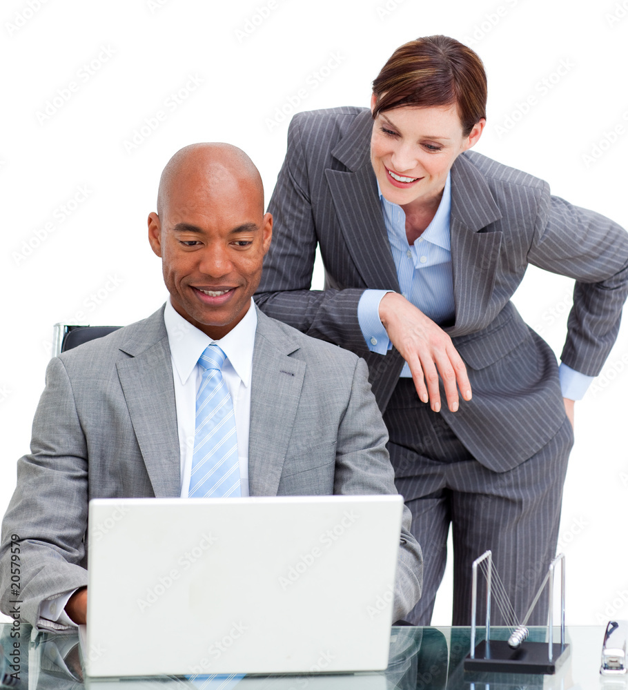Brunette manager assisting her colleague at a computer Brunette manager assisting her colleague at a computer