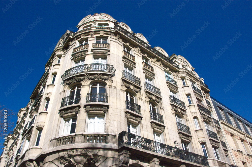 Immeuble de pierre blanche avec ciel bleu, Paris.