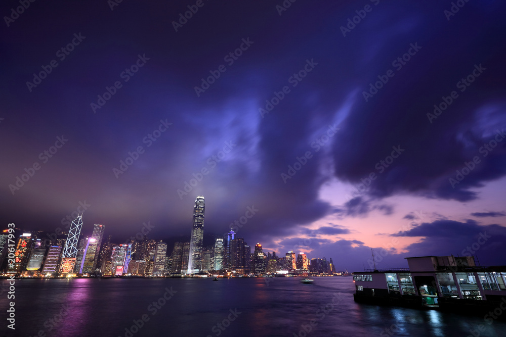 Hong Kong skyline at night, with dramatic sky.
