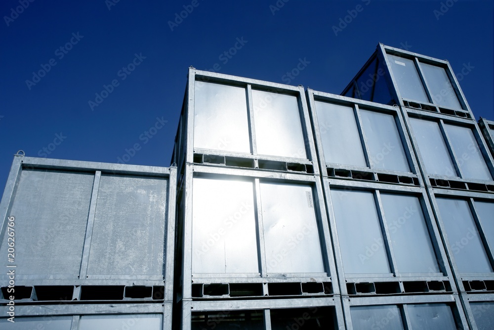 Containers stacked in silver rows over blue sky Containers stacked in silver rows over blue sky