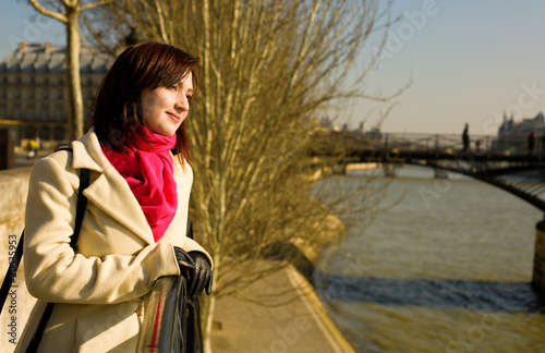 Beautiful woman in Paris on the Seine embankment near the pedest photo