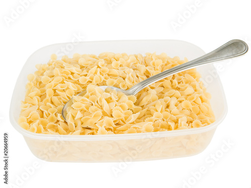 One side curled short-cut pasta with spoon in plastic container.