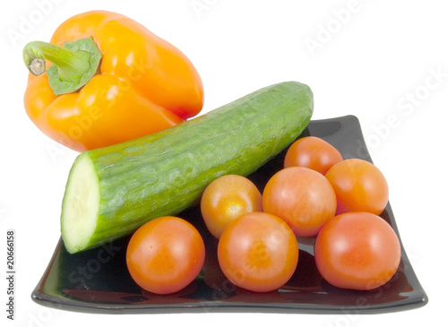 pepper, tomatoes and cucumber on black plate
