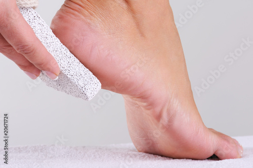 woman scrubbing foot by pumice photo