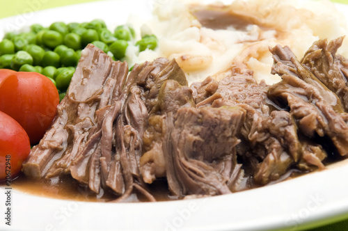 pot roast dinner with gravy mashed potatoes peas photo