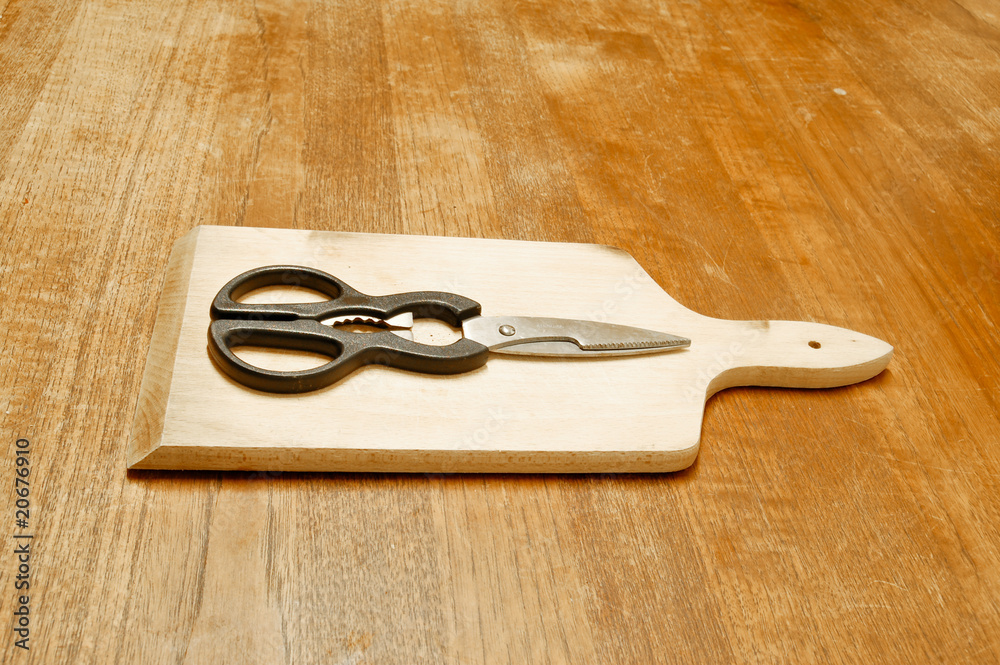 Ciseaux et planche posées sur une table en bois Ciseaux et planche posées sur une table en bois