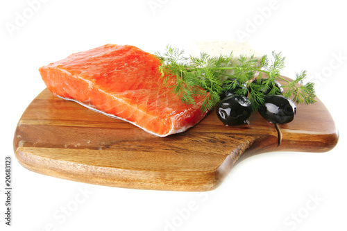 pink smoked salmon on wooden plate with white cheese