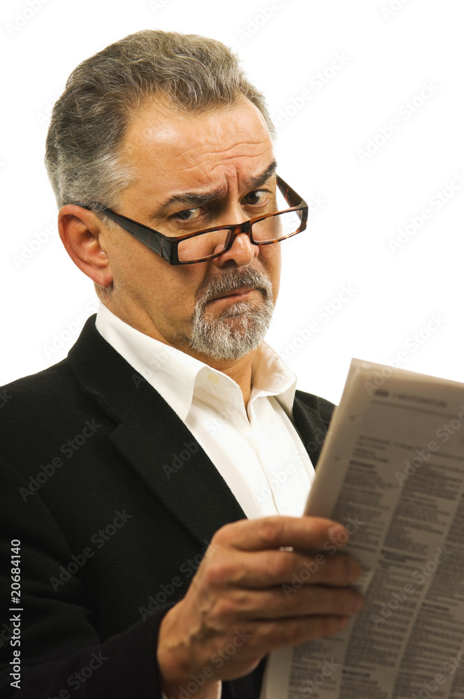 Businessman wearing glasses holds a newspaper.