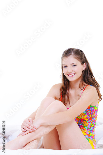 Cute fresh pretty young girl sitting on bed