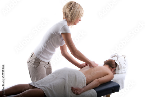 Massage therapist giving a back massage to a girl