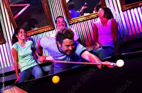 Young adults at a nightclub playing pool