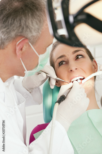 Patient bei Zahnarzt - Behandlung mit Bohren