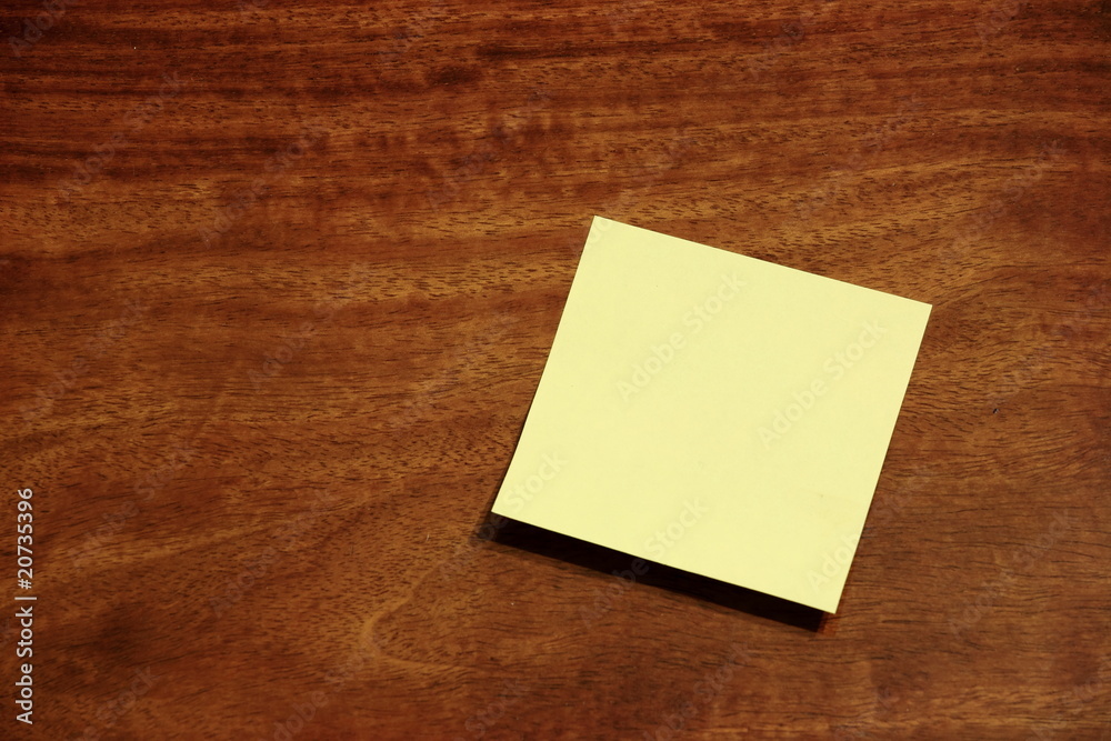 Yellow sticky memo note on wooden background Yellow sticky memo note on wooden background