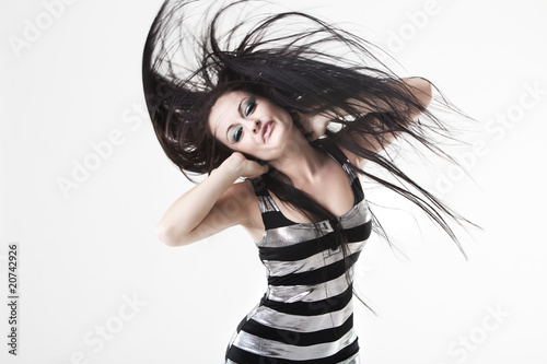 Young woman flicking very long dark hair