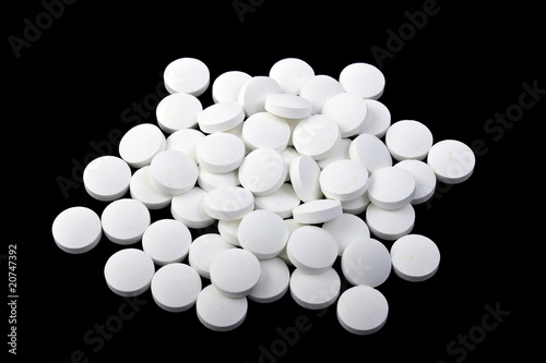A handful of pills on a black background, isolated © Discovod