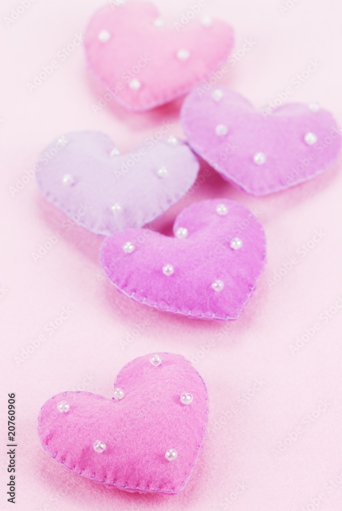 Fototapeta premium Five cloth hearts on a fiber textured background