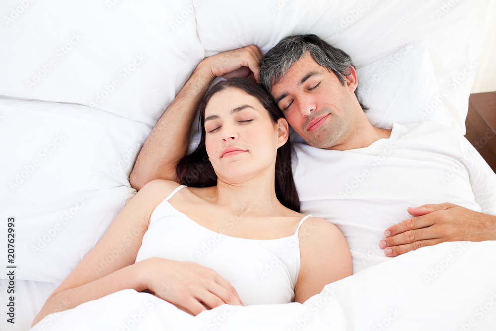 Affectionate couple hugging lying in their bed Affectionate couple hugging lying in their bed