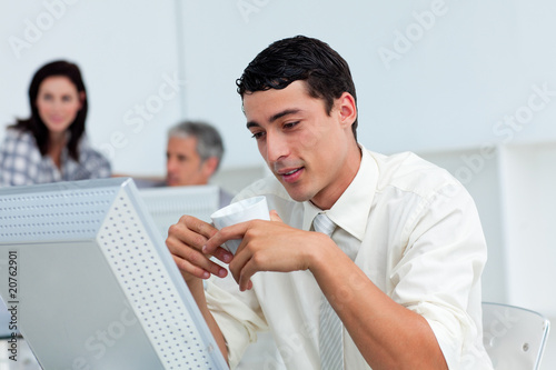 Serious businessman drinking a coffee at his desk