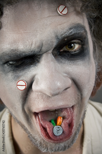 crazy man's face with pill on the tongue