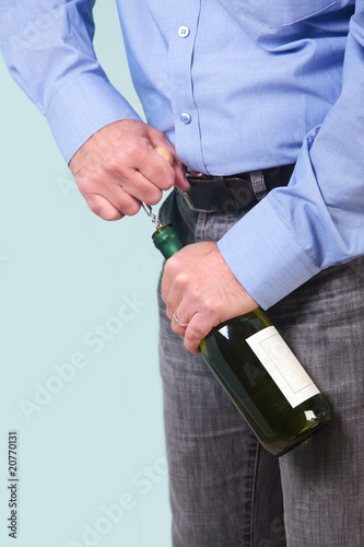 Man opening a bottle of white wine