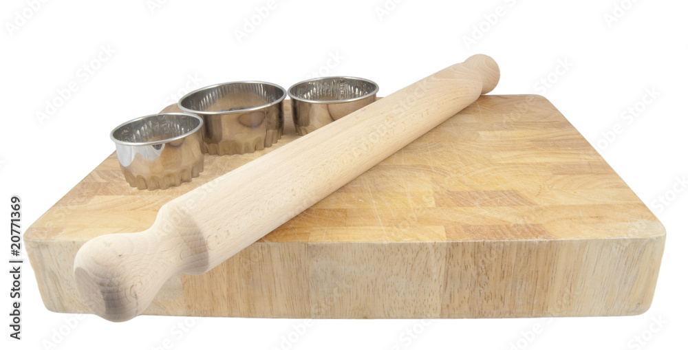pastry cutters and rolling pin on board isolated on white
