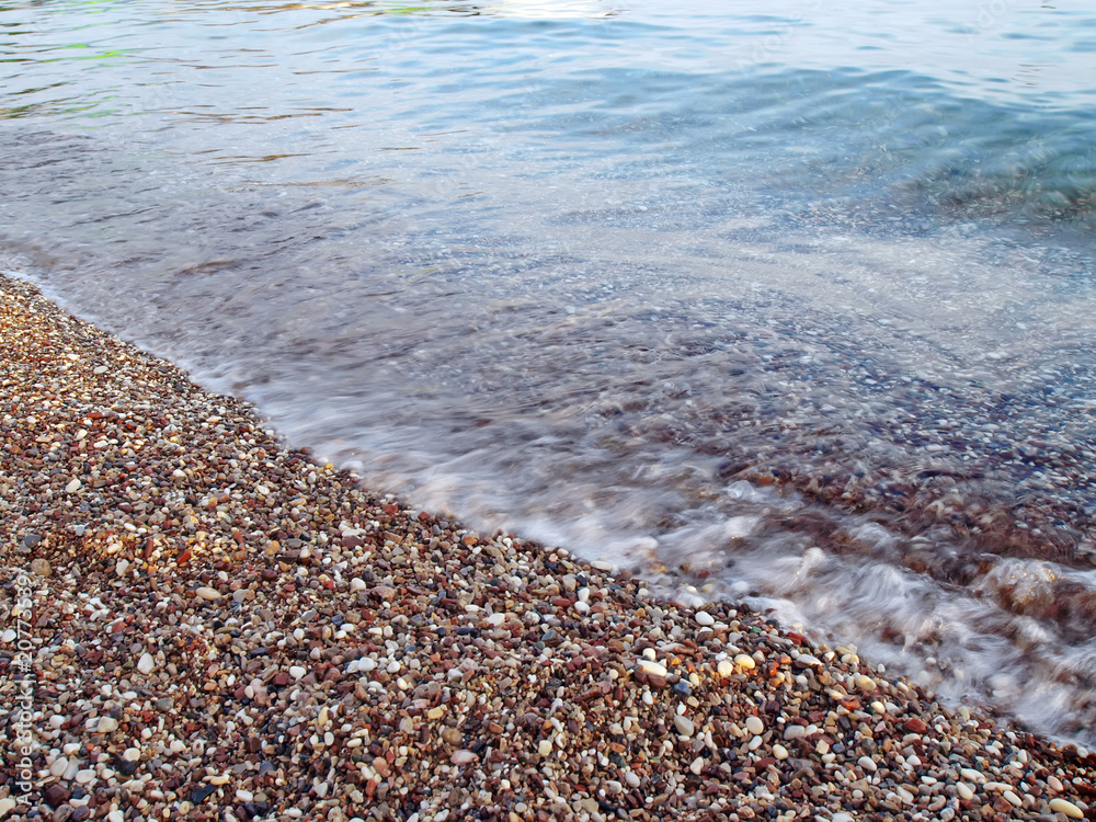 motion blurred wave on pebble beach motion blurred wave on pebble beach
