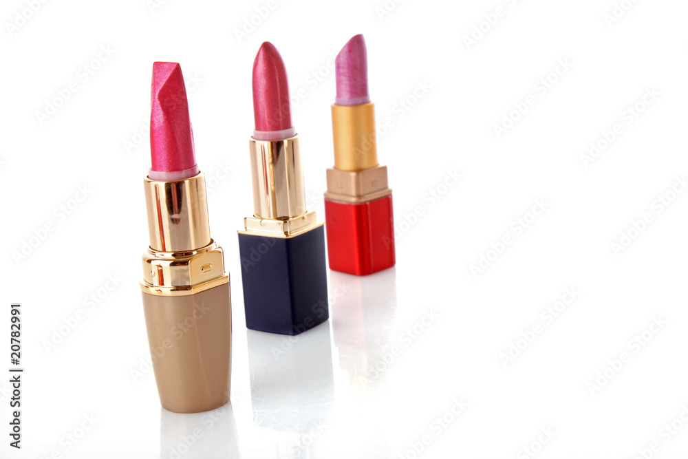Fototapeta premium three colored lipsticks on white background