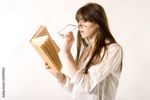 jeune femme lit en faisant loupe avec ses lunettes
