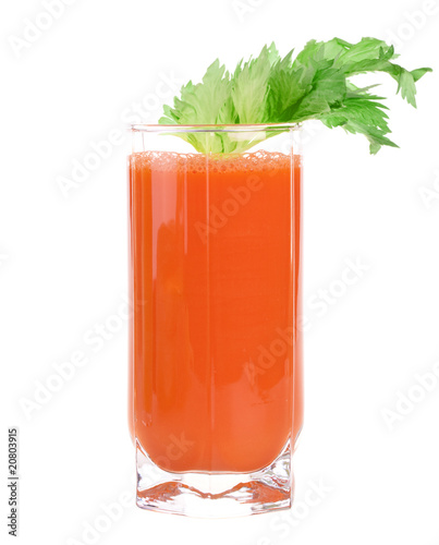 A glass of fresh carrot juice with celery leaves