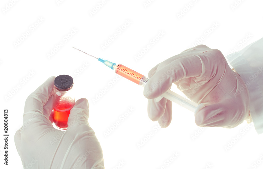 Medic holding a syringe for injection Medic holding a syringe for injection